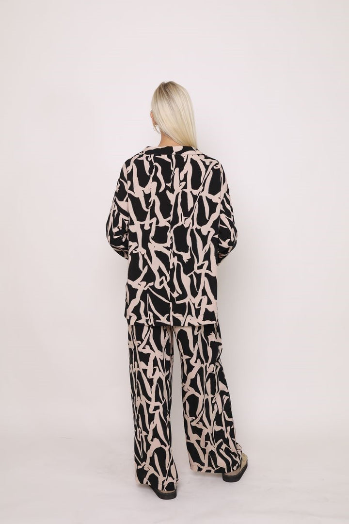 Back view of the Alex Pant in Black Cinnamon from Ivy Vibe, showing the relaxed wide-leg fit, high-rise waist, and smooth drape of the soft fabric.