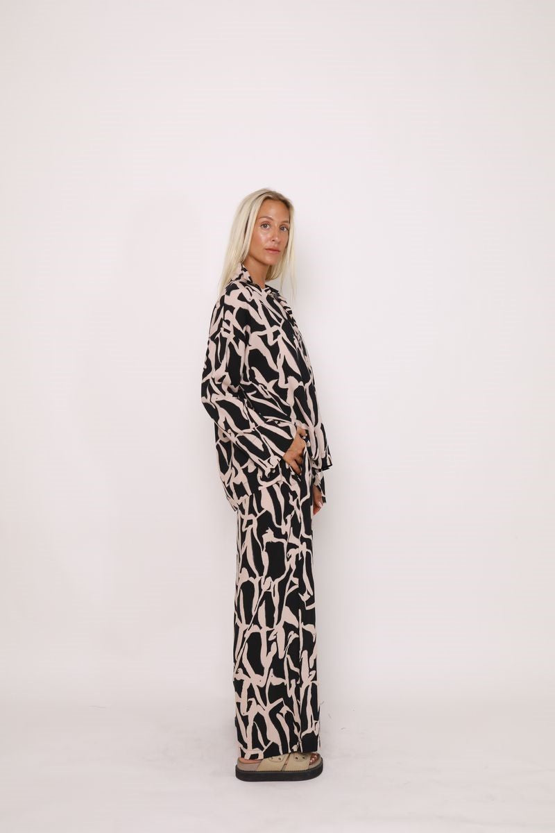 Side view of the Alex Pant in Black Cinnamon from Ivy Vibe, highlighting the wide-leg silhouette, high waist, and flowy fabric for a flattering drape.