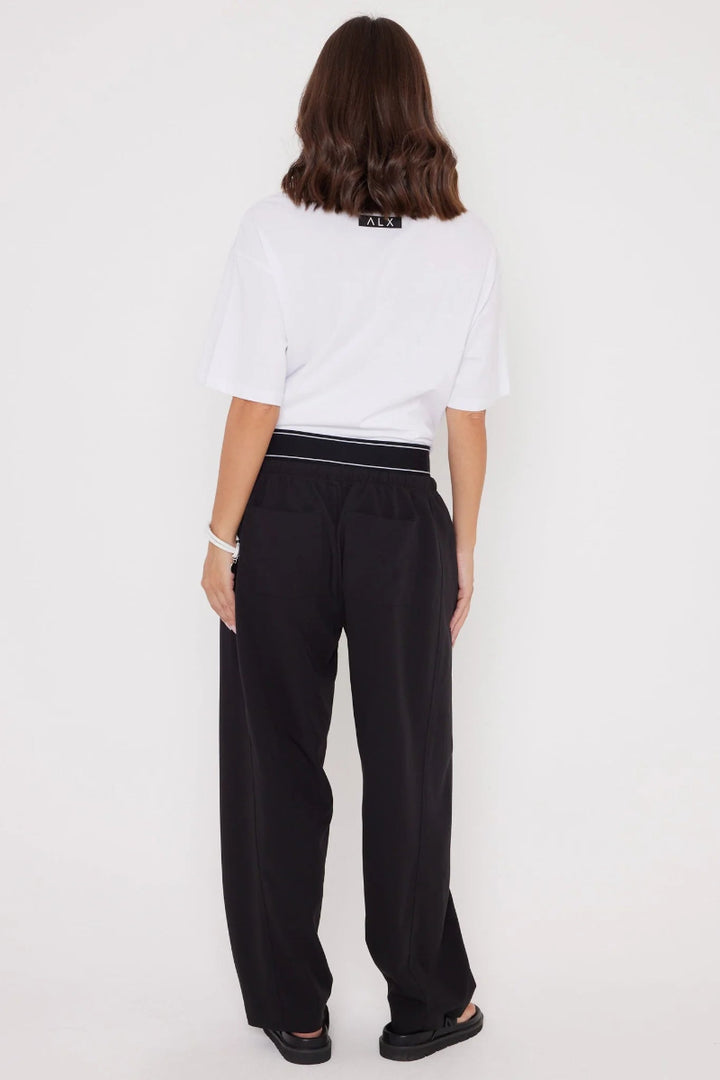 Person wearing a white shirt and black pants on a white background