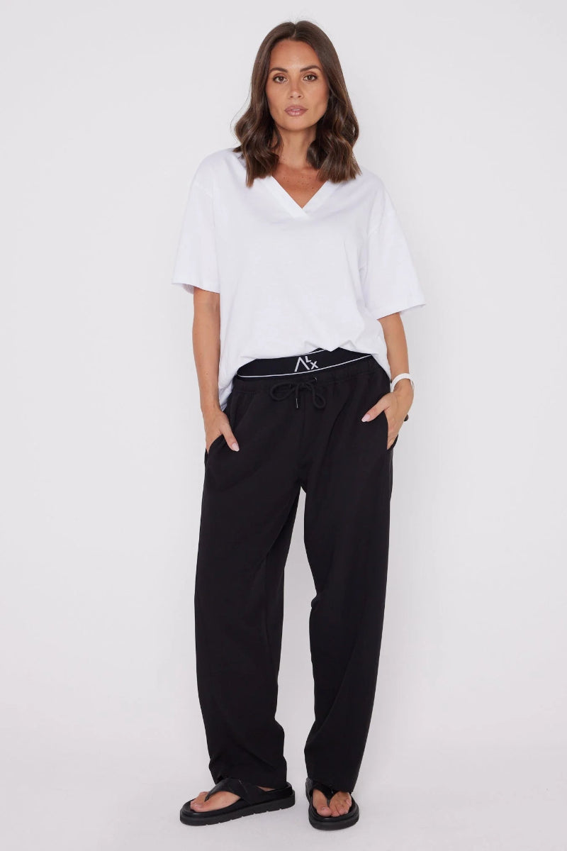 Woman wearing a white top and black pants on a white background