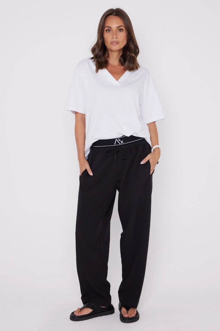 Woman wearing a white top and black pants on a white background