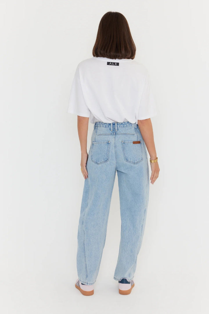 Person wearing light blue jeans and a white t-shirt on a white background