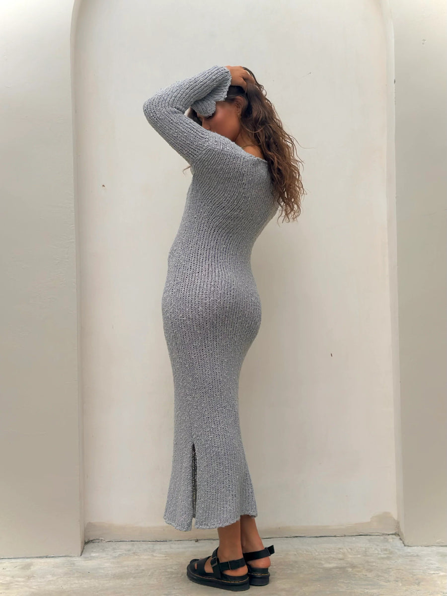 Back view of fitted gray knit midi dress and sandals.