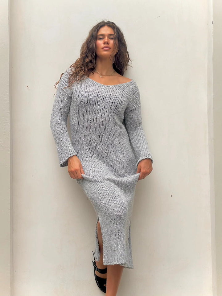 Front view of woman in gray knit midi dress with slit.