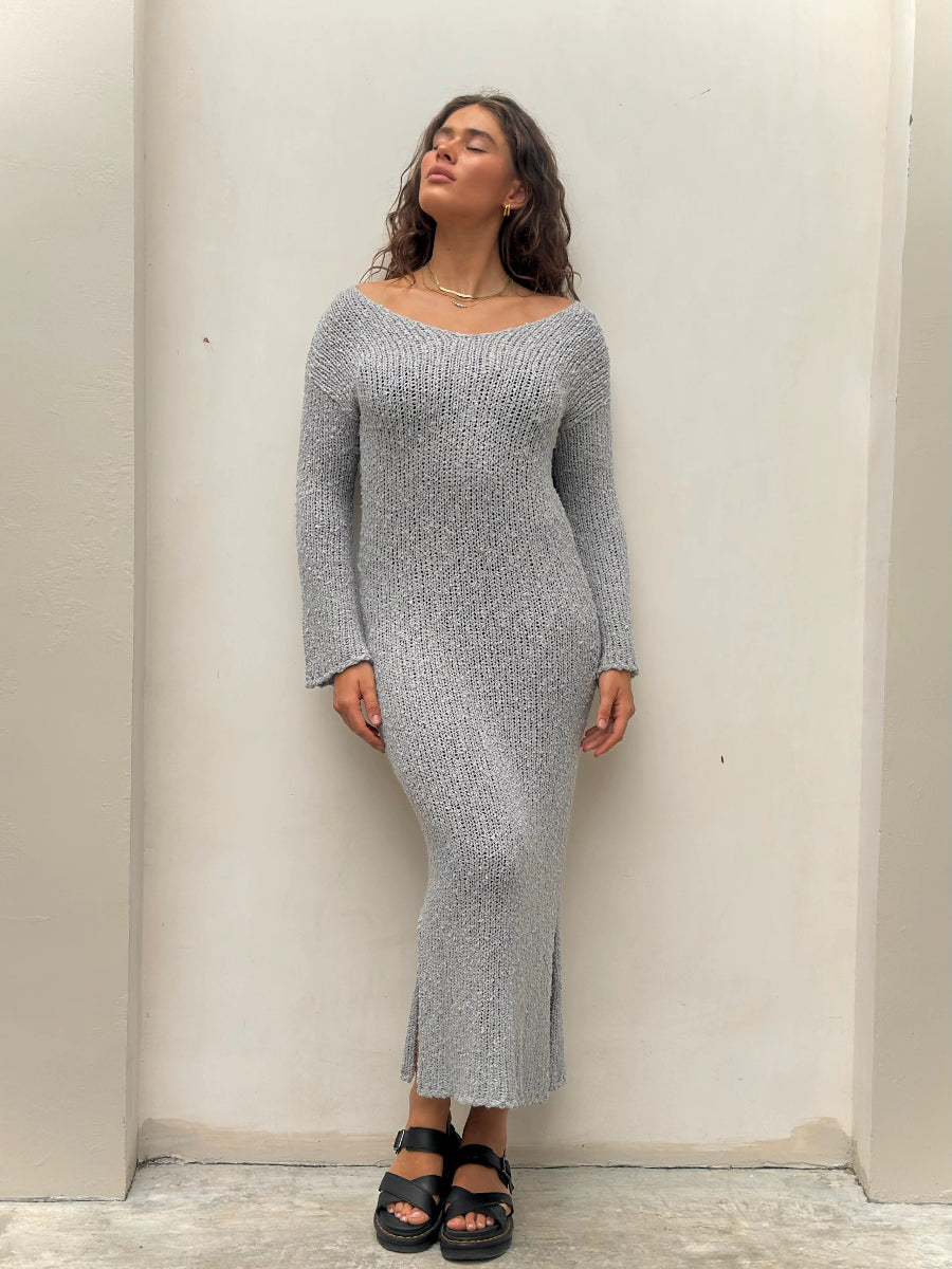 Woman standing in gray knit long-sleeve midi dress.