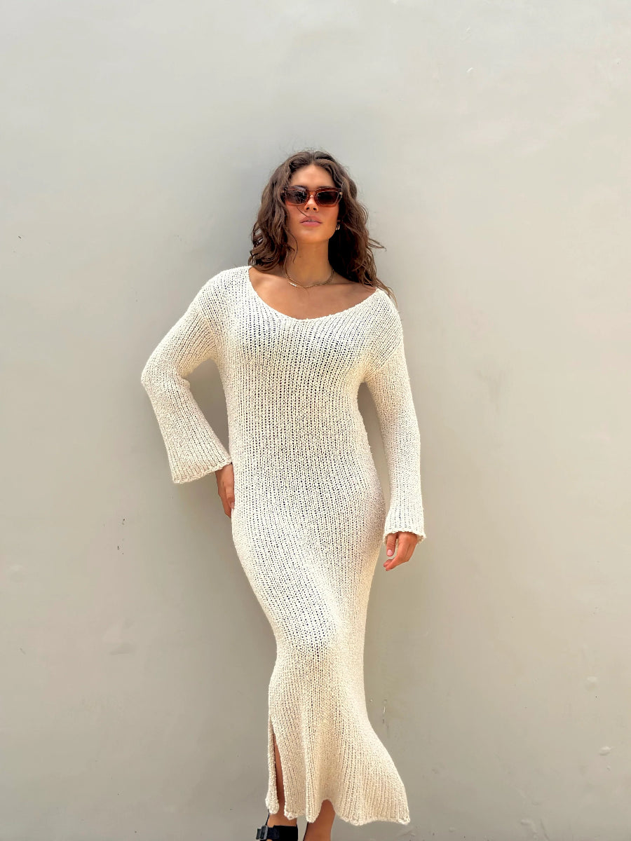 Front view of cream knit dress with long sleeves and slit hem.