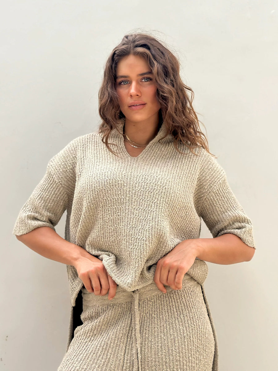Close-up of textured beige knit top and drawstring waist.