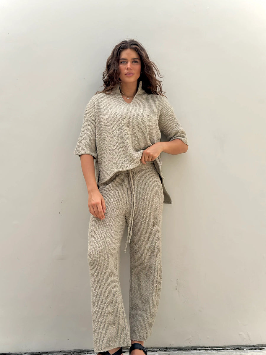 Full-length view of woman in beige knit lounge set.