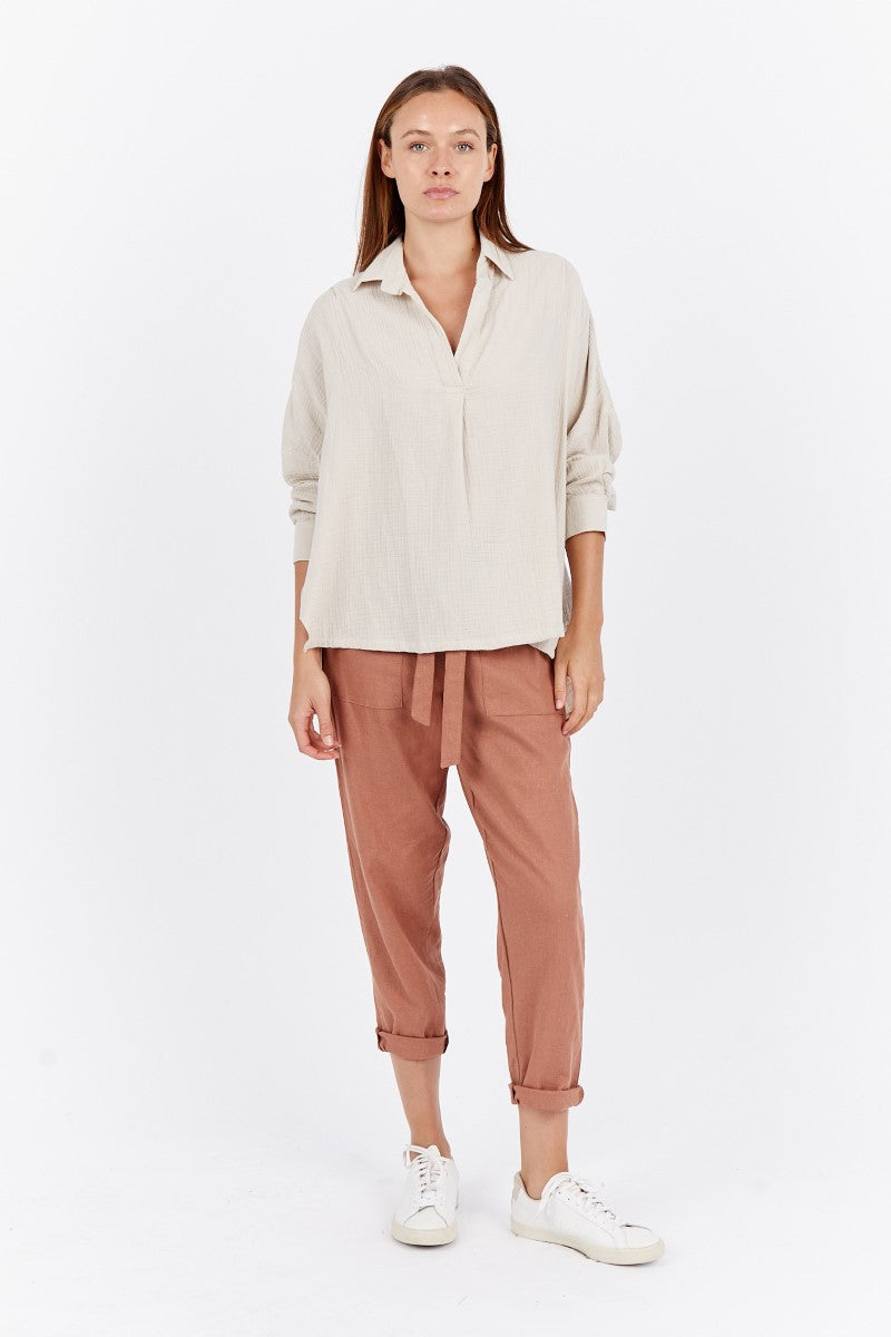 Front view of model wearing the Carbon Anja Slouch Tunic Top at Ivy Vibe, featuring a v-neck, collared neckline, 3/4 sleeves with buttoned cuffs, and a relaxed oversized fit.