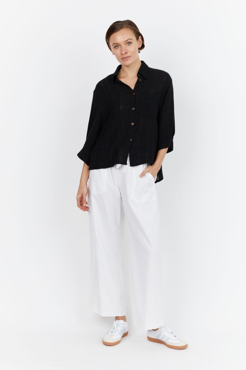  Front view of model wearing the Carbon Aventi Top in black at Ivy Vibe, featuring a collared neckline, button-up front, 3/4 sleeves, and relaxed fit.