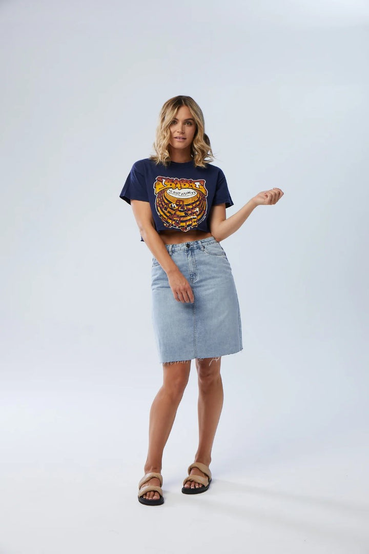 Woman wearing a graphic t-shirt and denim skirt on a white background