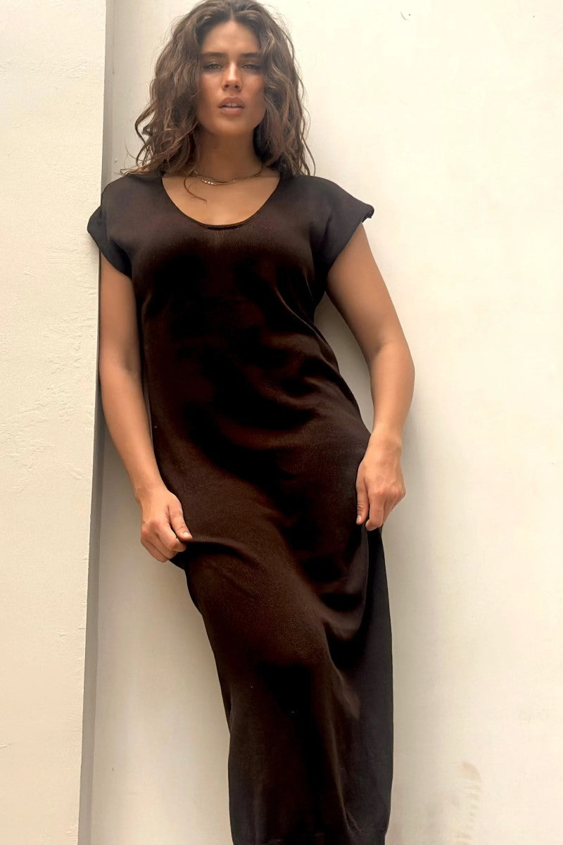 Woman wearing a brown dress against a white background