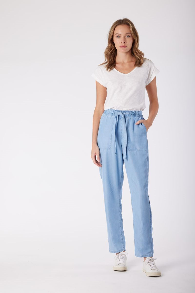 Woman wearing a white t-shirt and light blue pants on a white background