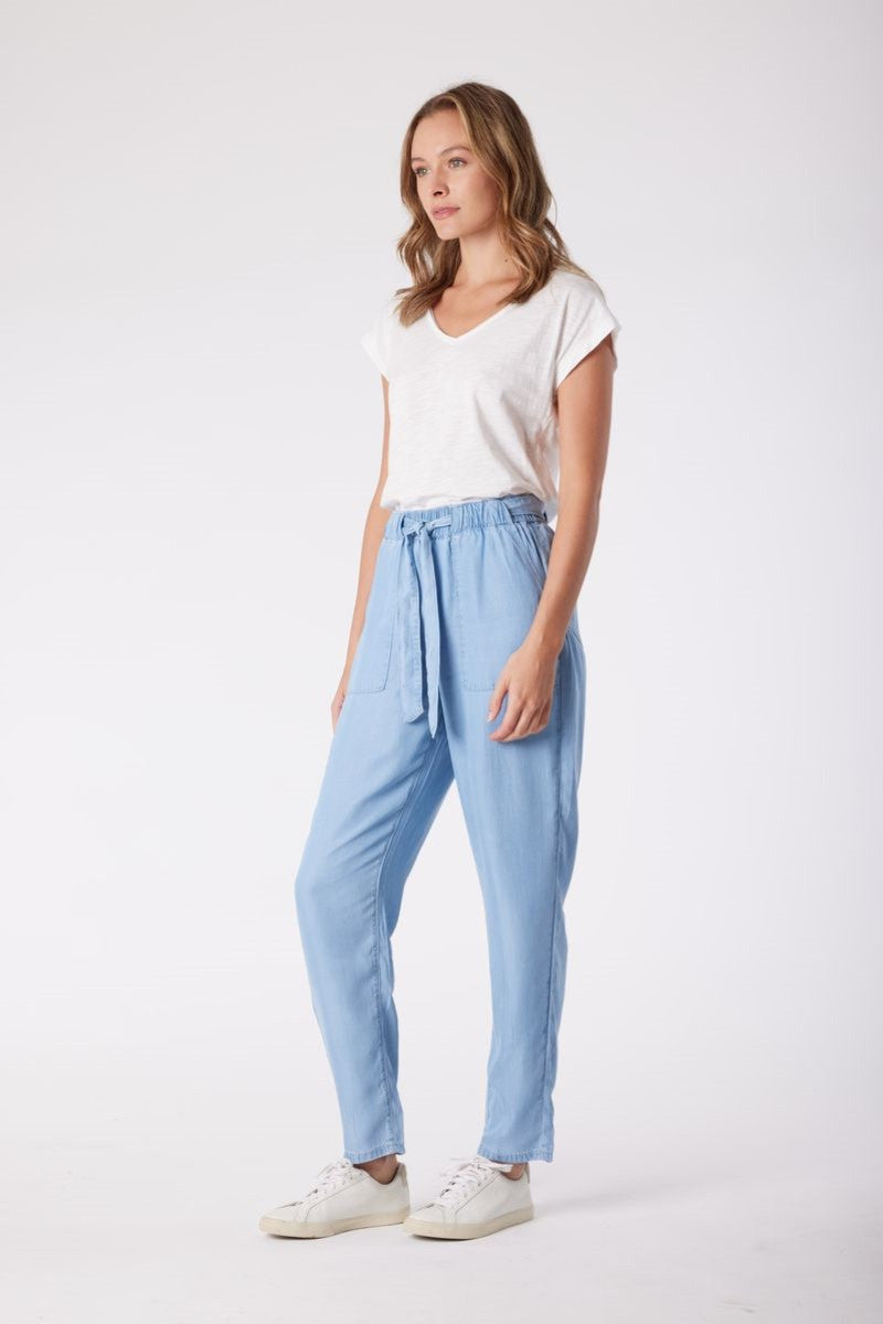 Woman wearing a white t-shirt and light blue pants on a white background