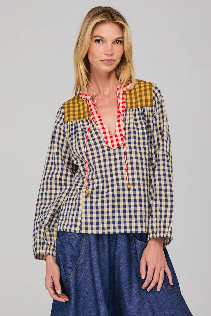 Woman wearing a colorful checkered blouse with a gray background