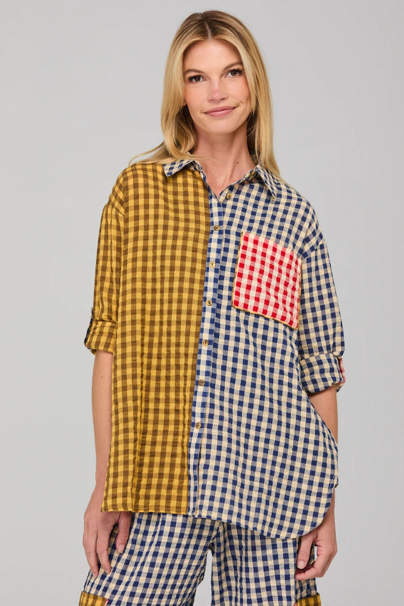 Woman wearing a checkered shirt with a red pocket on a gray background