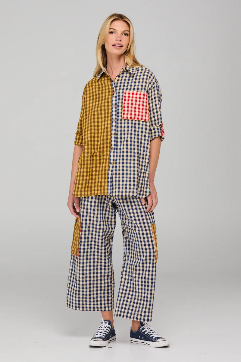 Woman wearing a checkered outfit with a red pocket on a gray background