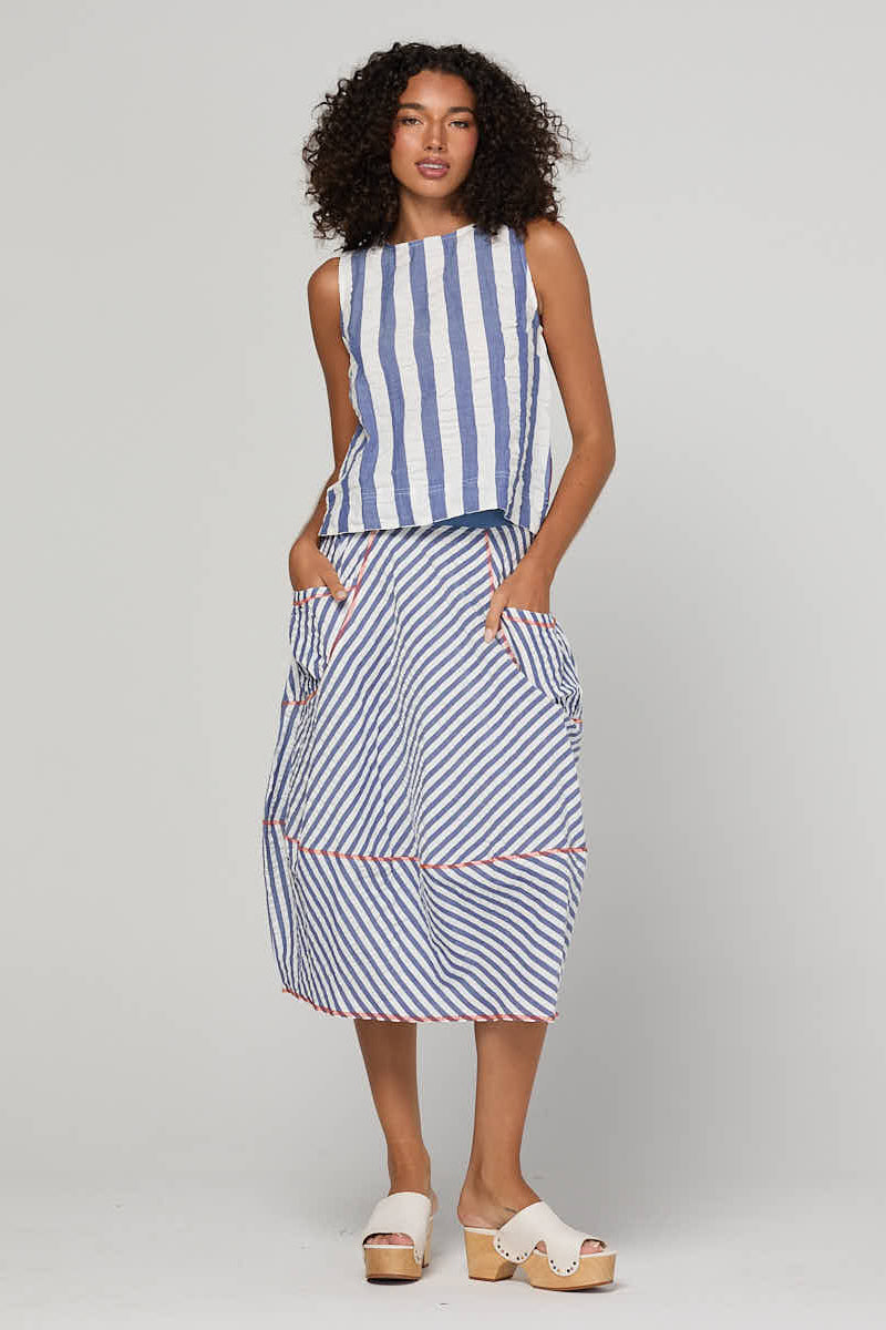 Woman wearing a blue and white striped dress on a gray background