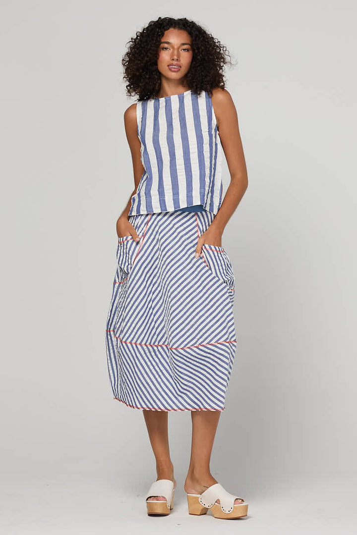Woman wearing a blue and white striped dress on a gray background