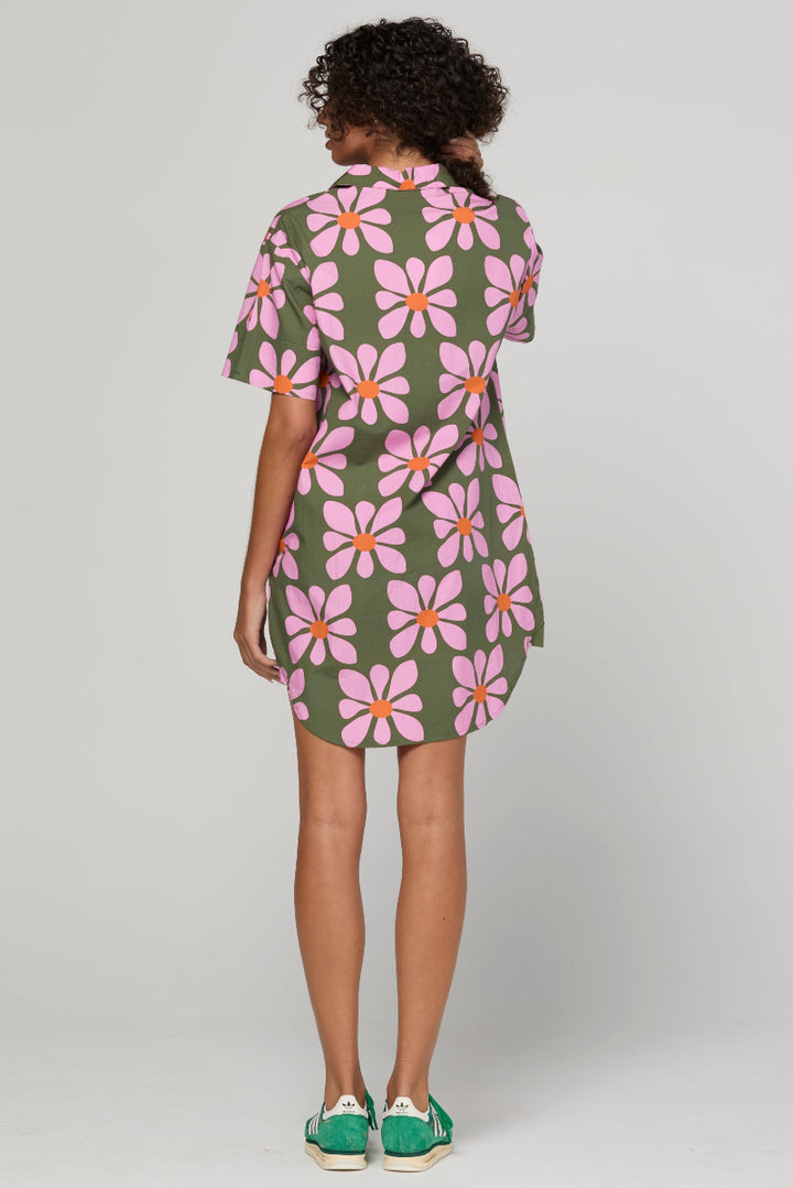 Woman wearing a floral dress with a plain background