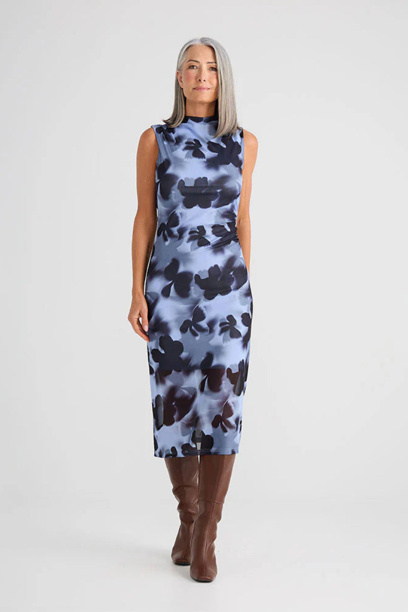 Woman wearing a sleeveless dress with a floral pattern on a white background