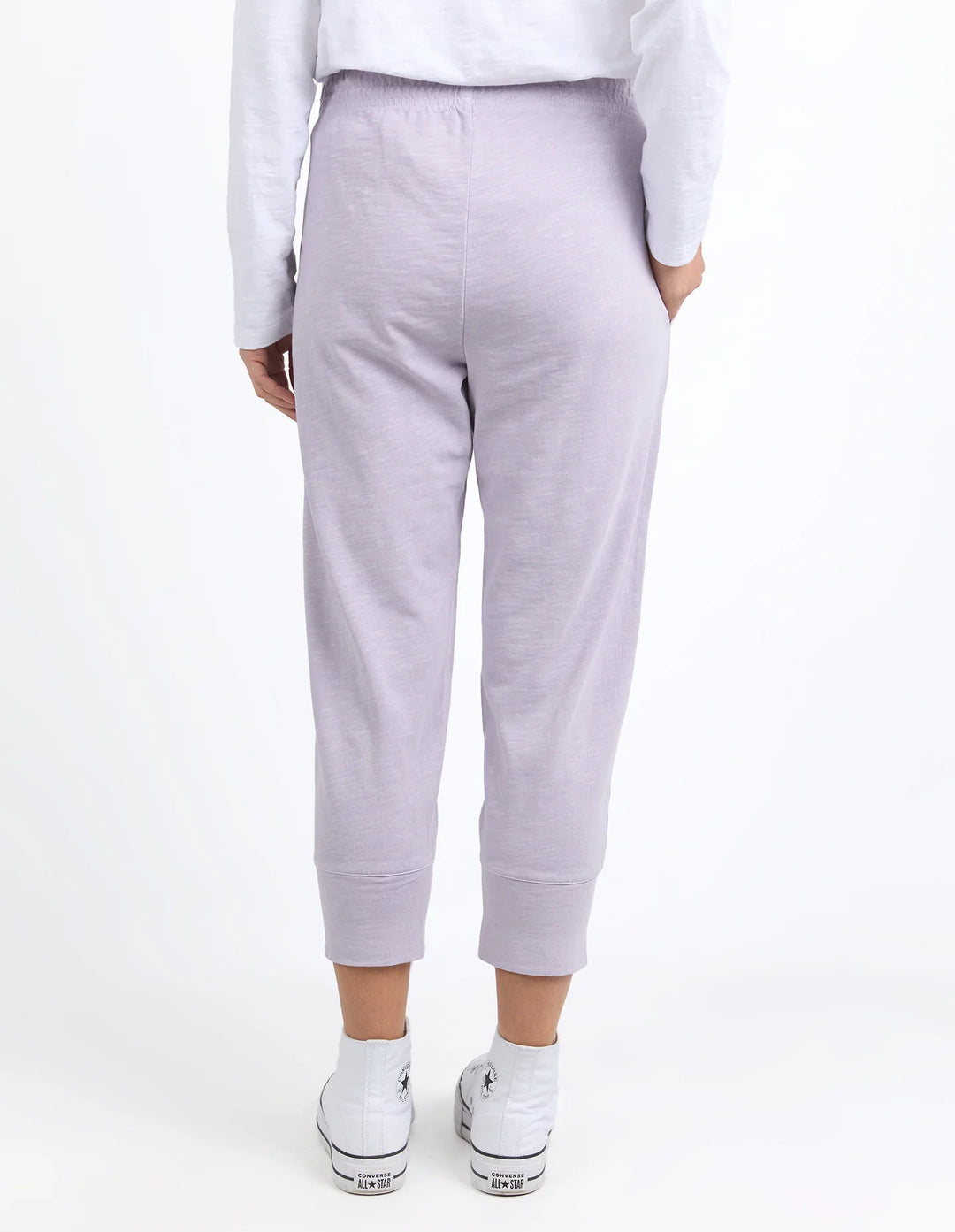 Person wearing light purple sweatpants on a white background