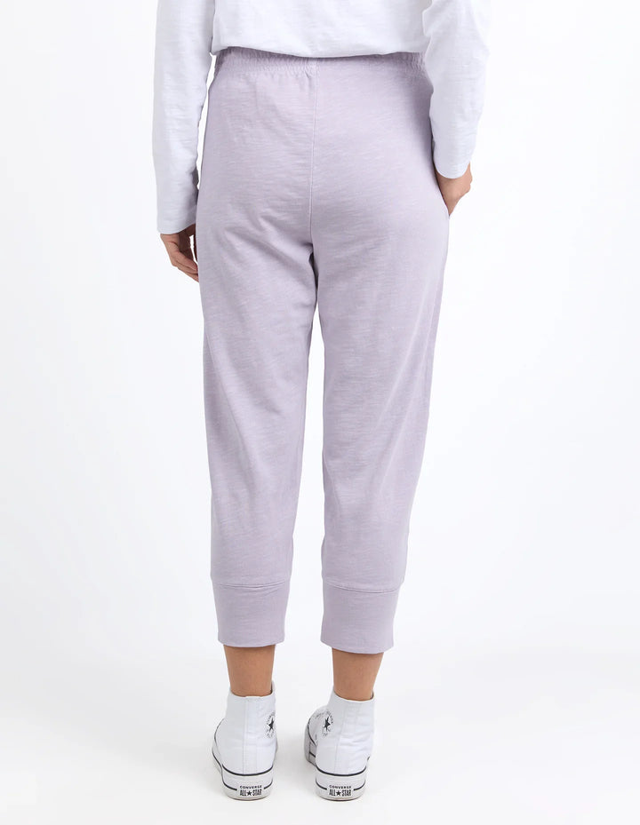Person wearing light purple sweatpants on a white background