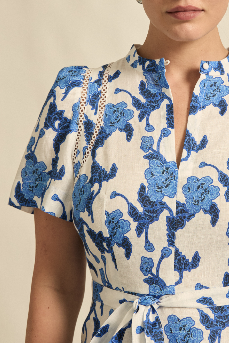 This close-up view of the Cable Dress in Azure Bouquet reveals the intricate circular lace inserts, soft linen texture, and delicate gathering on the tulip sleeve.
