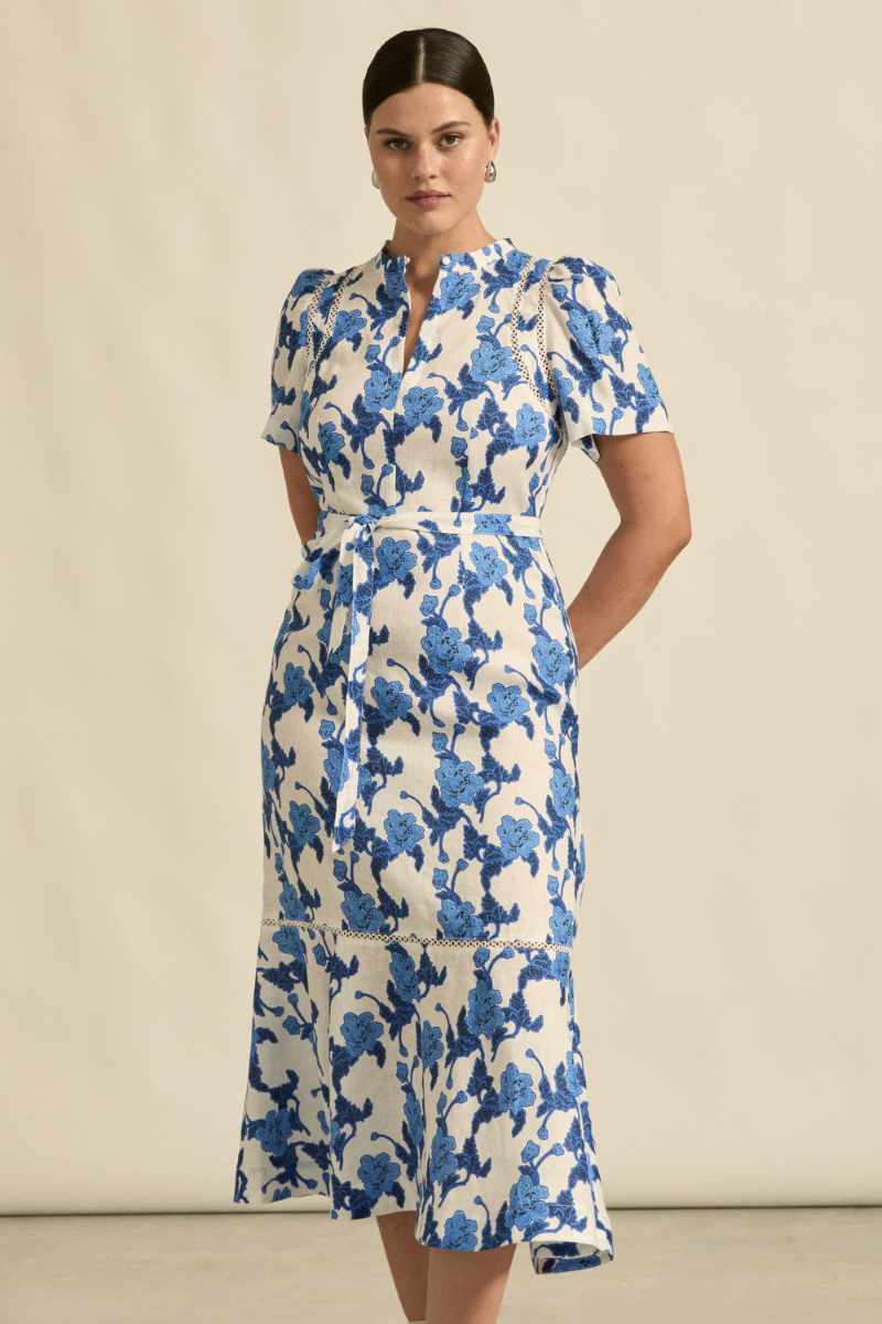 This front view of the Cable Dress in Azure Bouquet showcases its elegant A-line silhouette, tulip sleeves, and delicate lace detailing, available at Ivy Vibe.
