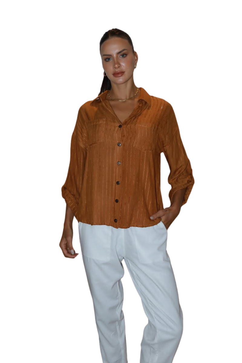 Woman wearing a brown button-up shirt and white pants on a white background