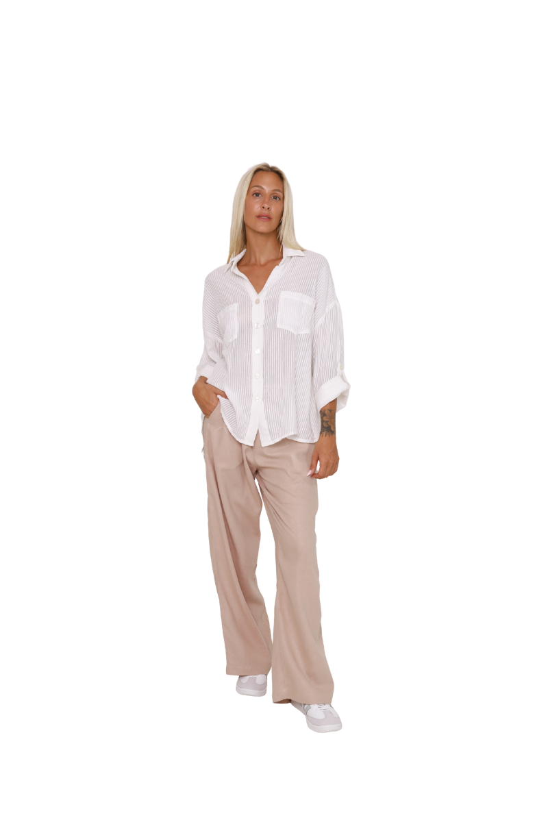 Woman wearing a white blouse and beige pants on a white background