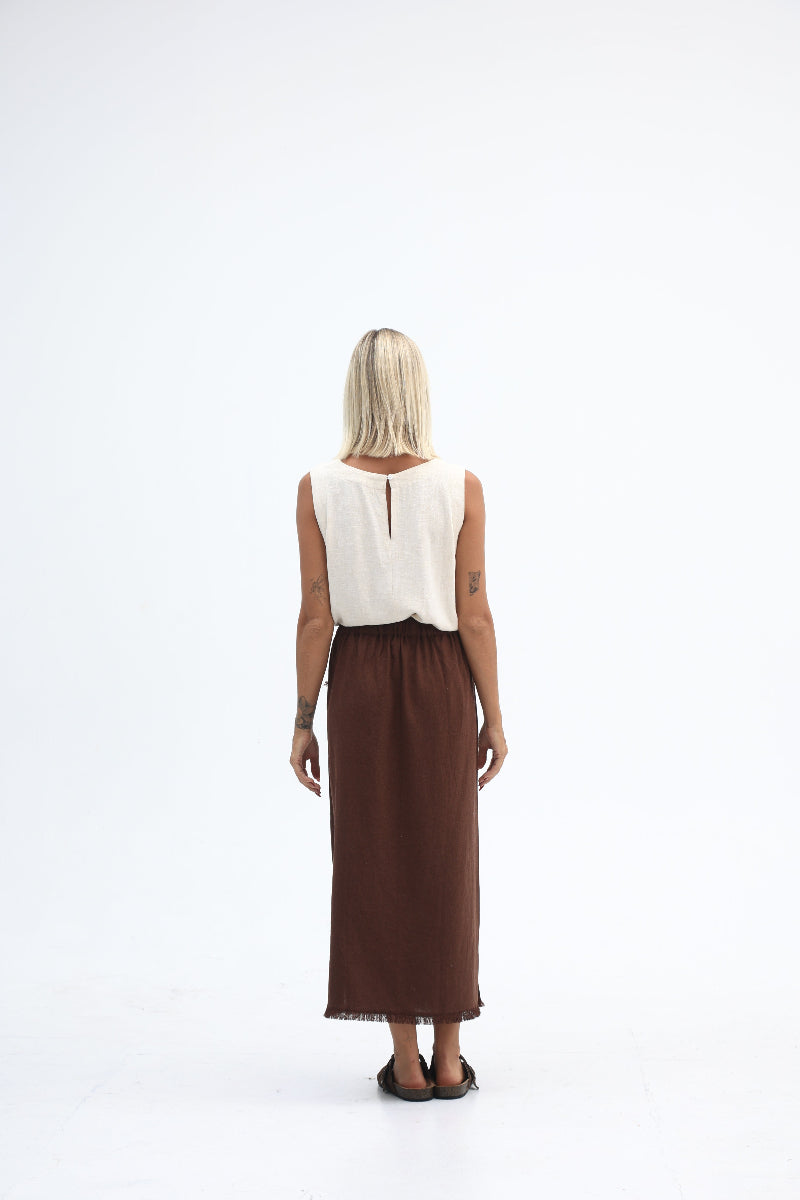 Woman wearing a white top and brown skirt on a white background