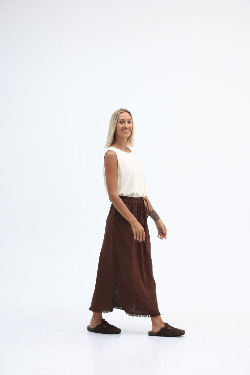 Woman wearing a white top and brown skirt on a white background