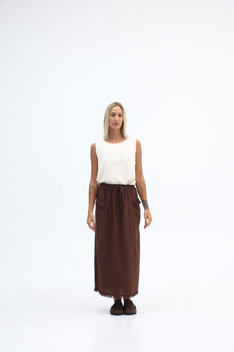 Person wearing a white top and brown skirt on a white background