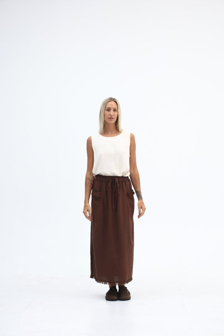 Person wearing a white top and brown skirt on a white background
