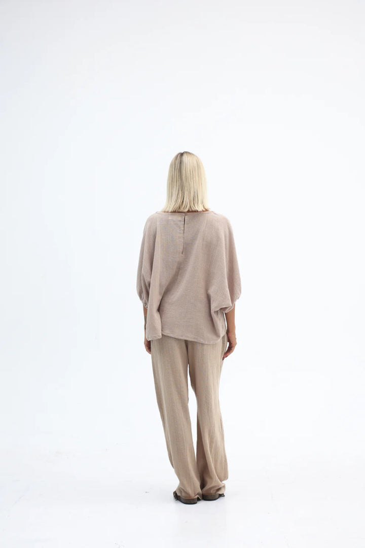Woman wearing a beige outfit on a white background