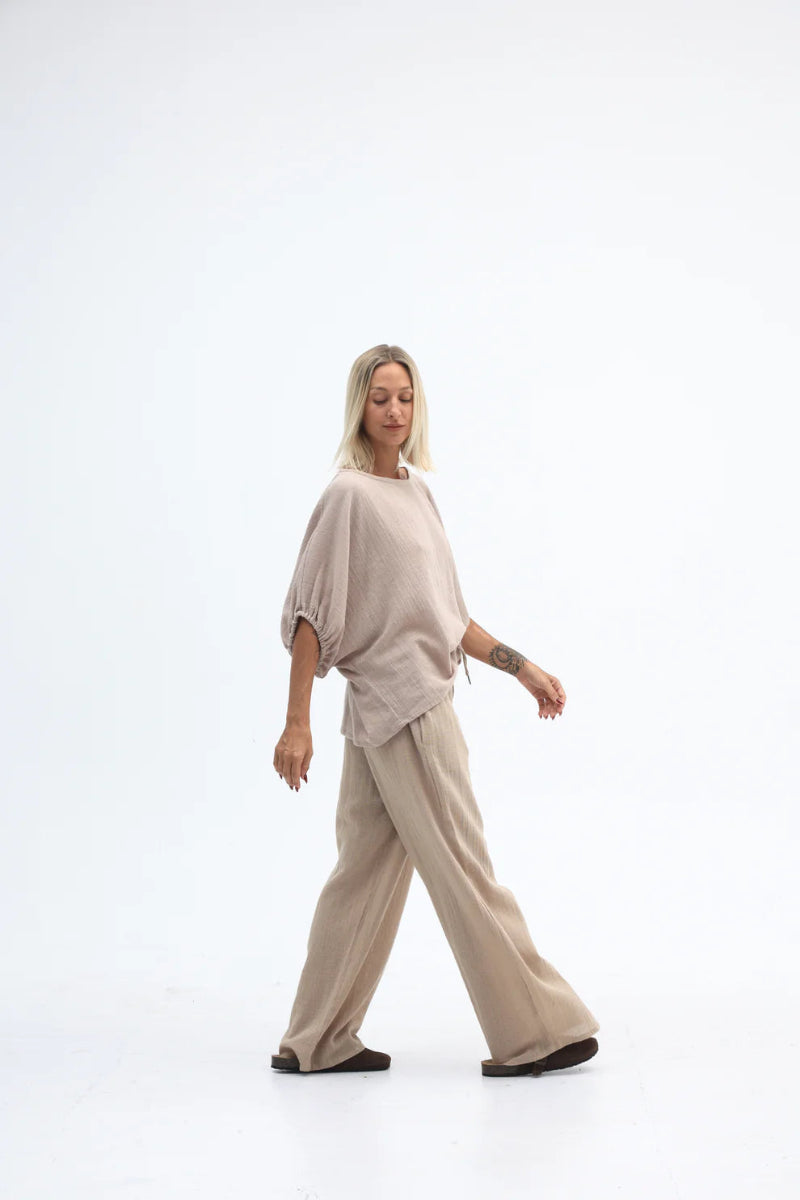 Woman wearing a beige outfit on a white background