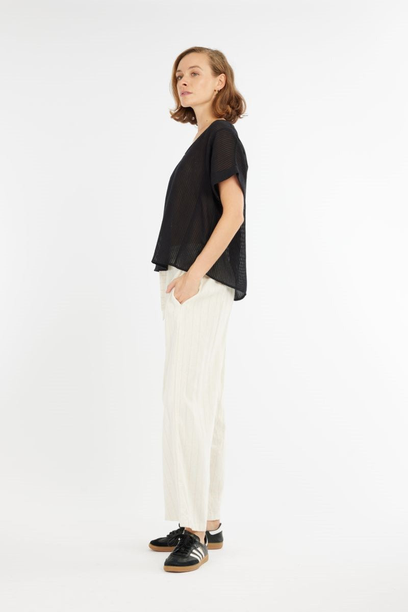 Side view of the Carmen Striped Top in black from Ivy Vibe, highlighting the relaxed fit, short sleeves, and curved hem with a subtle textured stripe design.