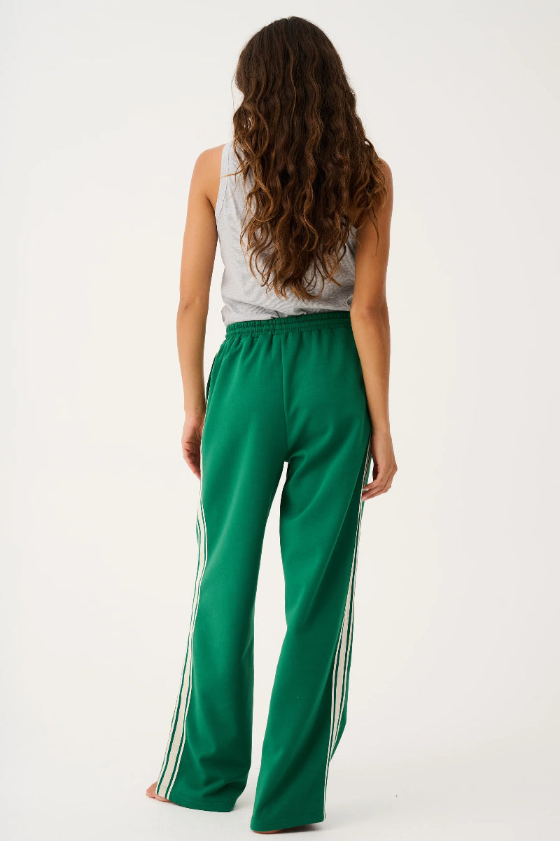 Woman wearing green pants with white stripes on a white background