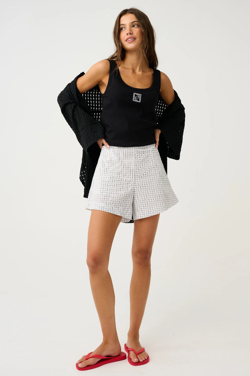 Front view of check mini shorts styled with black tank.