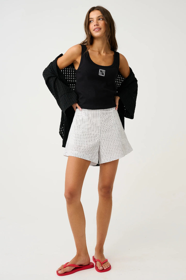 Front view of check mini shorts styled with black tank.