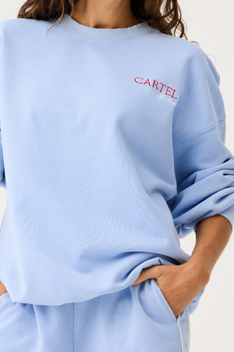 Light blue sweatshirt with 'CARTEL' logo on a plain background