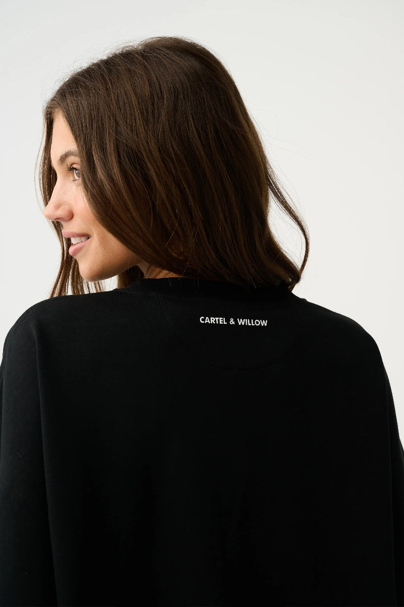 Back view of black oversized top with logo.