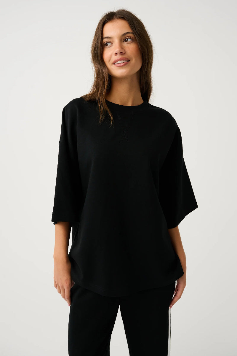 Front view of black relaxed-fit top and pants.