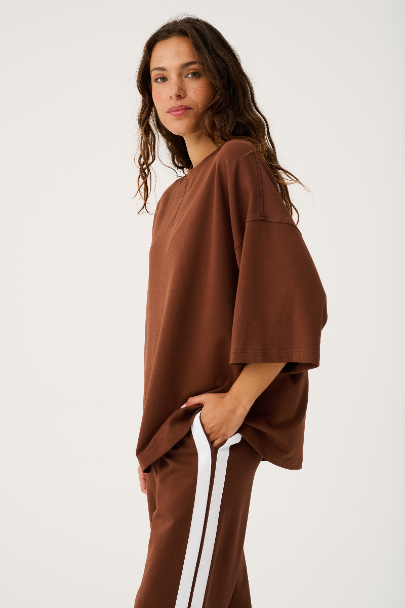 Woman wearing a brown outfit with a white background