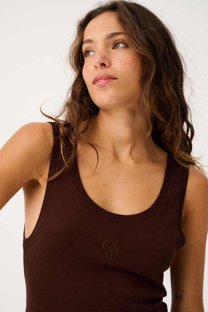 Woman wearing a brown tank top with a logo on a white background