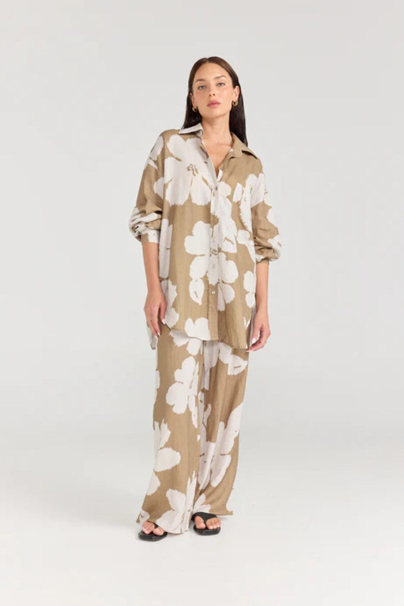 Woman wearing a beige and white floral outfit on a white background
