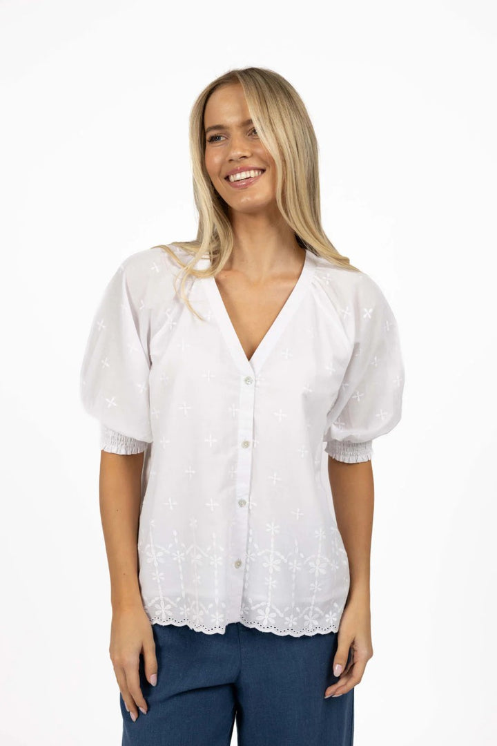 Woman wearing a white blouse with puff sleeves on a white background