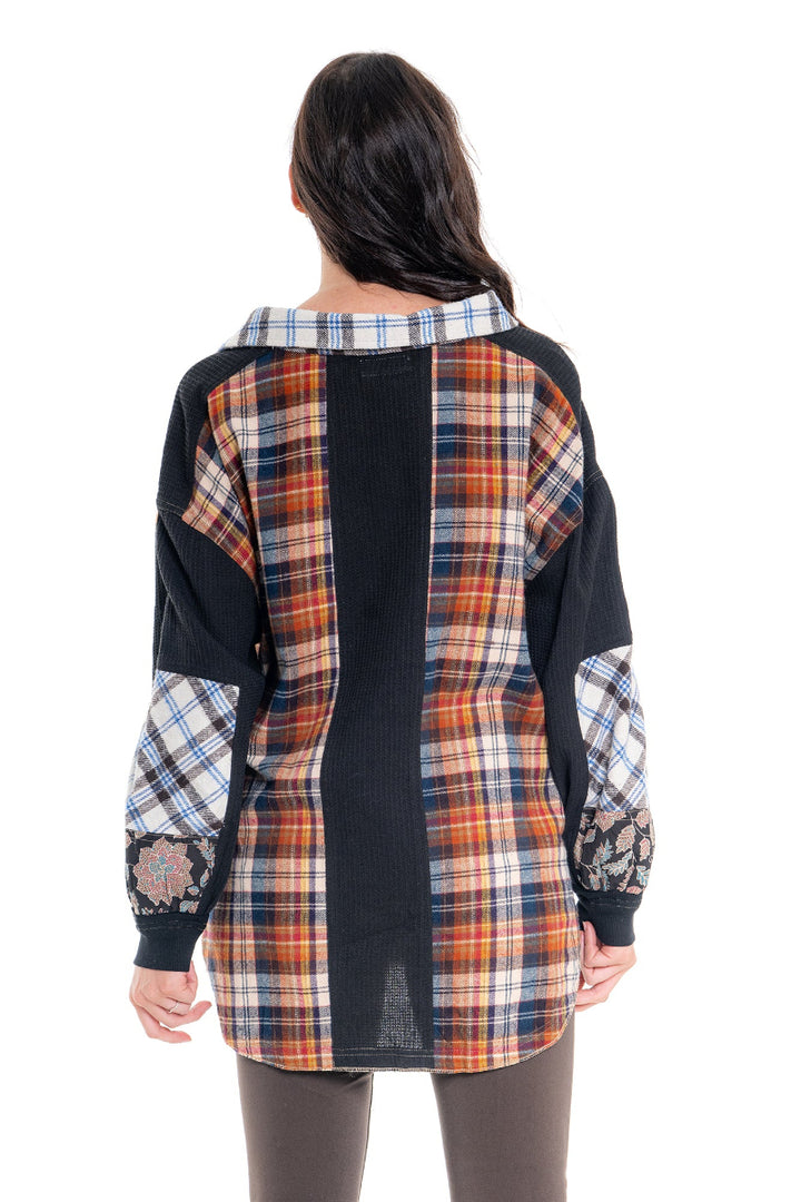 Woman wearing a plaid shirt with a black base and colorful sleeves on a white background