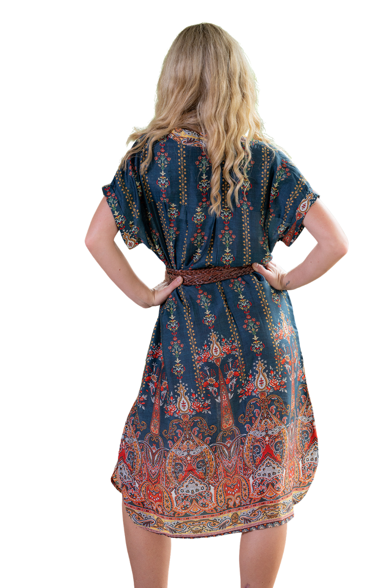 Woman wearing a patterned dress with a belt on a white background